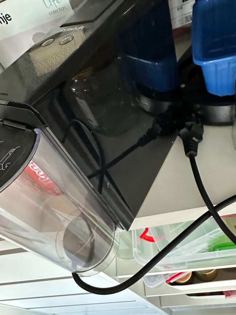 Aparat de cafea Nespresso închis într-un dulap, nefolosit